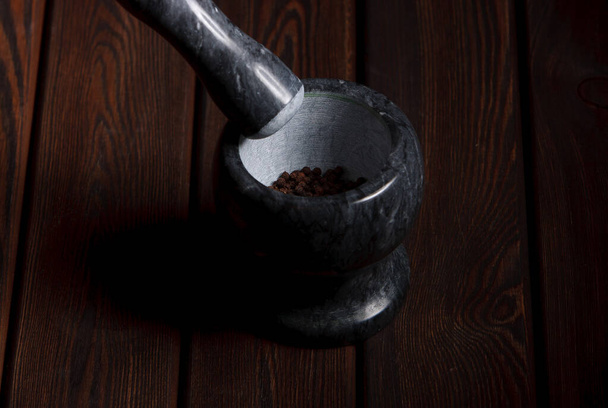 mortar and pestle on the wooden table black background - Fotografie, Obrázek