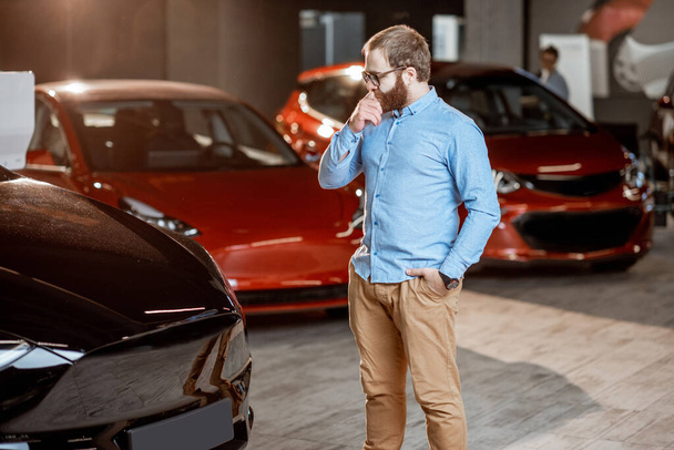 Man choosing electric car at the showroom - Photo, Image
