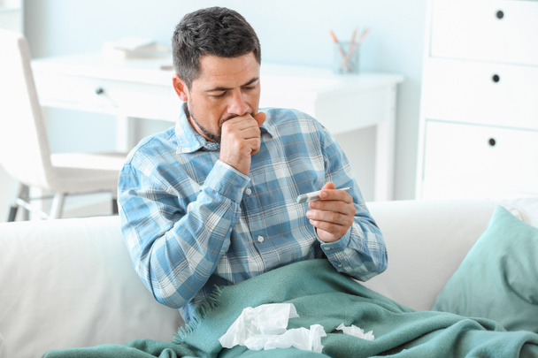 Homem doente com temperatura de medição da gripe em casa
 - Foto, Imagem