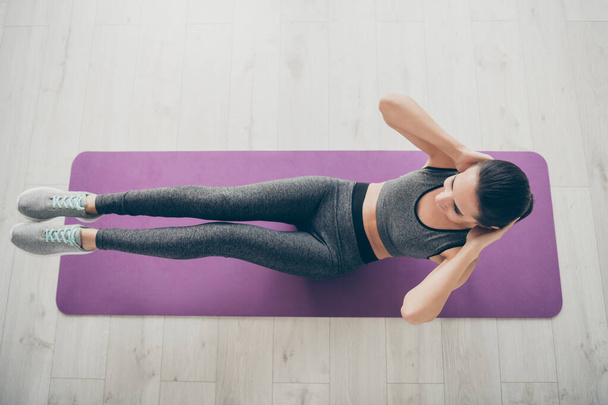 Top above high angle view photo of cheerful positive sport girlfriend wearing sportswear doing crunches indoors on carpet floor - Fotografie, Obrázek