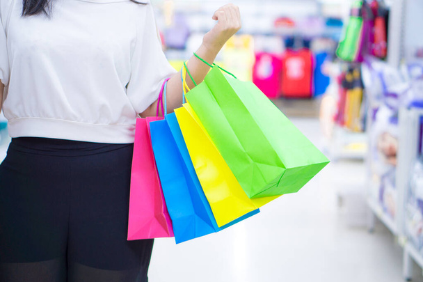 Zblízka žena ruka drží mnoho nákupních tašek v nákupním m - Fotografie, Obrázek