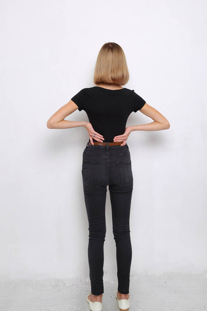 back view of caucasian teen girl in the studio posing against light background - Photo, image