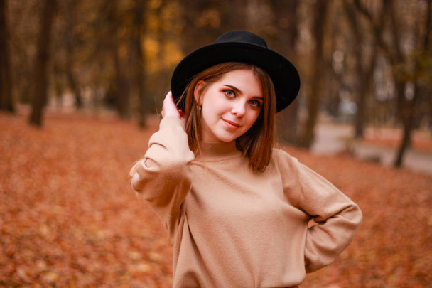 Осенняя девушка в парке. Свитер, шляпа и кожаная юбка. Стильный
 - Фото, изображение