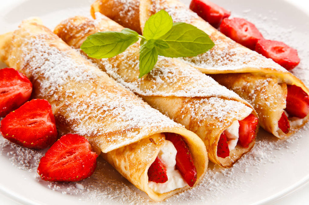 Crepes with strawberries and cream on white background  - Fotoğraf, Görsel