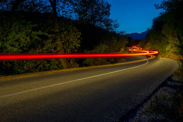 Trilhas de luz traseira na estrada da noite
 - Foto, Imagem