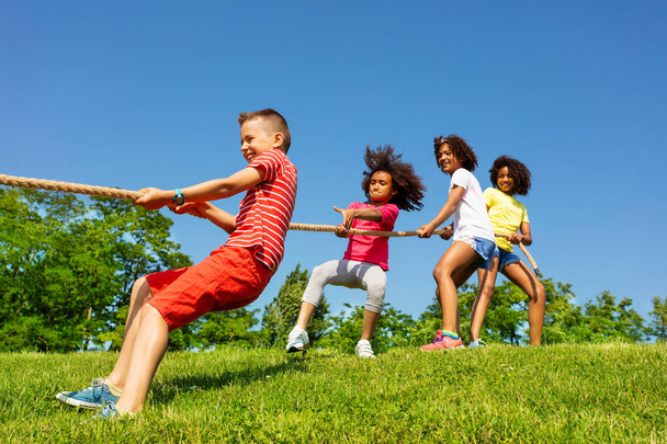 Groupe d'enfants dans le jeu compétitif de tirer le cordon de corde dans le parc
 - Photo, image