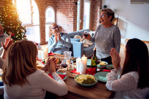 Сім'я і друзі обідають вдома святкуючи Різдвяну ніч традиційною їжею та прикрасою, роблячи тост на Новий рік найкращими побажаннями
 - Фото, зображення