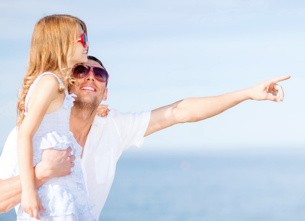 Pai feliz e criança em óculos de sol sobre o céu azul
 - Foto, Imagem