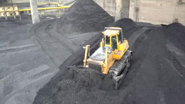 tractor Bulldozer recogiendo carbón negro en el campo de suministro de la central termoeléctrica. - Metraje, vídeo