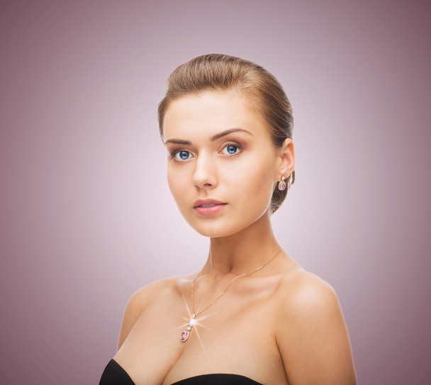 Woman wearing shiny diamond earrings and pendant - Foto, imagen