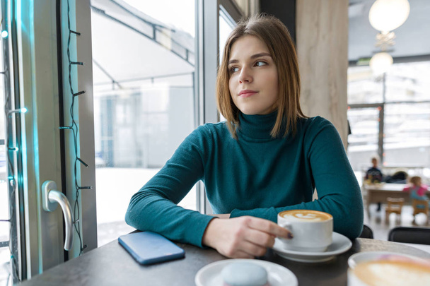 Jeune femme au repos à la pause dans un café avec une tasse de boisson chaude
 - Photo, image
