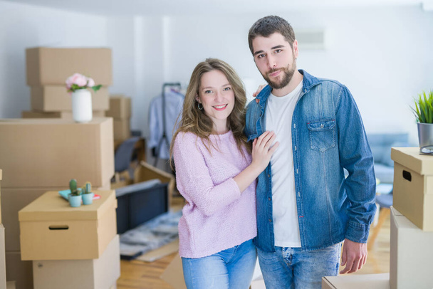 Jeune beau couple regardant heureux ensemble déménageant dans une nouvelle maison
 - Photo, image