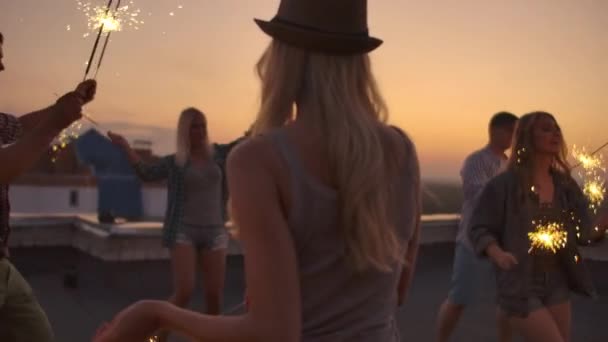 Jovens mulheres de chapéu dançam com luz de bengala
 - Filmagem, Vídeo