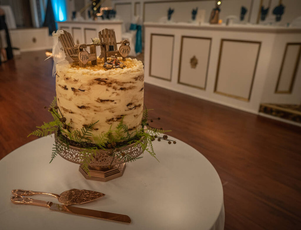Vista lateral de un pastel de boda de estilo rústico con temática alrededor de camping
  - Foto, Imagen