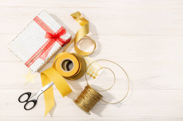 Flat lay of Christmas gifts, decoration paper, ribbons and scissors. Christmas gift concept - Photo, Image