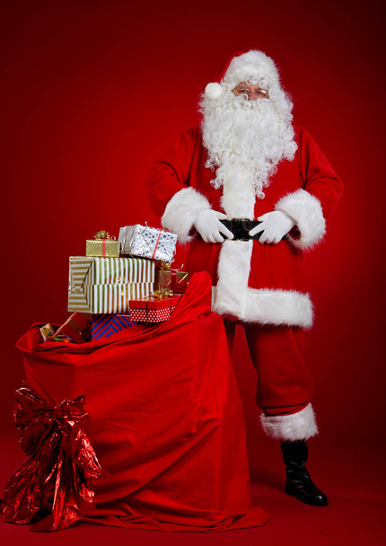 サンタクロースはプレゼントでいっぱいの袋を持っています - 写真・画像