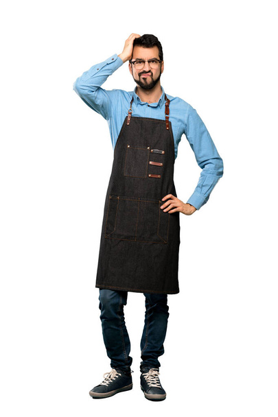 Full-length shot of Man with apron with an expression of frustration and not understanding over isolated white background - Foto, Bild