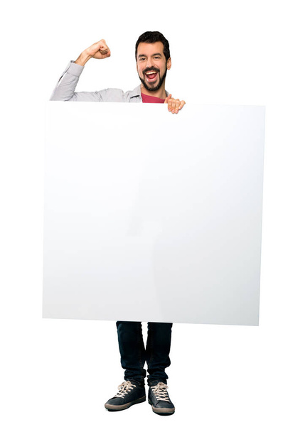 Hombre guapo con barba sosteniendo un cartel vacío
 - Foto, imagen