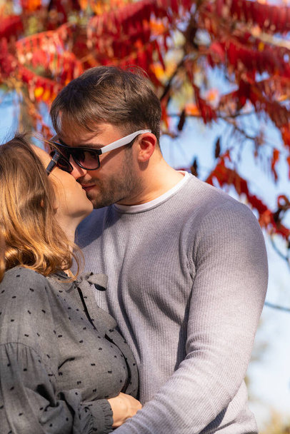 Young couple kissing in an autumn park - Fotó, kép