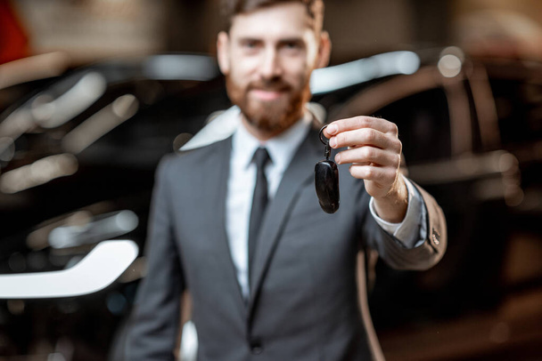 Salesman with key at the car dealership - Foto, immagini