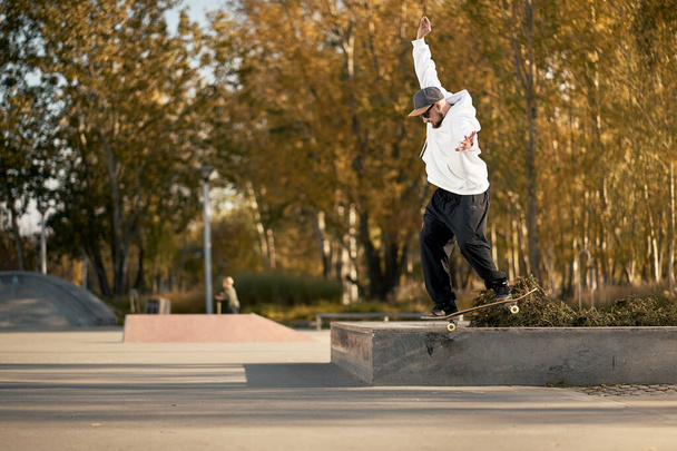 Uomo in skatepark cavalca skateboard nella calda giornata autunnale
 - Foto, immagini