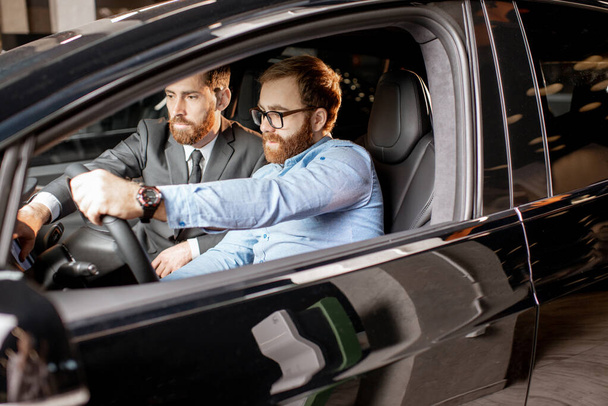 Sales manager with a client looking at the vehicle interior - Valokuva, kuva