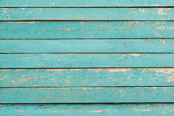 houten achtergrond, een fragment van de muur van een oud houten huis geschilderd in turquoise - Foto, afbeelding