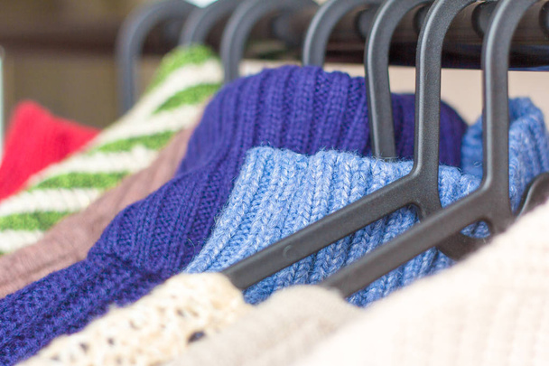 coisas de malha quentes, suéteres e vestidos pendurar em cabides
 - Foto, Imagem