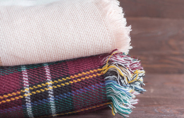 ζεστό σωρό κουβέρτες βρίσκονται σε ένα ξύλινο φόντο - Φωτογραφία, εικόνα