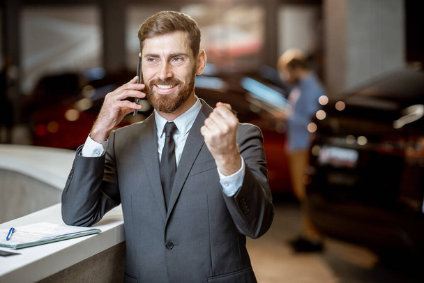 Businessman with car key in the showroom - 写真・画像
