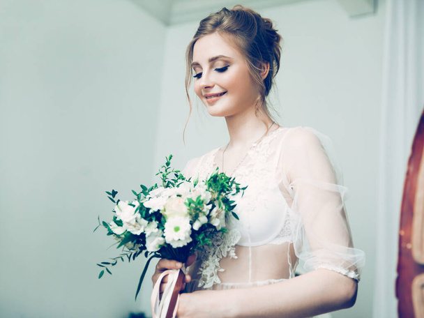 portrait of a pretty young bride with a wedding bouquet - Fotó, kép