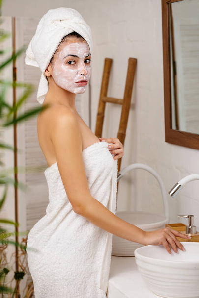 Woman is applying mask on her face - Foto, Imagen