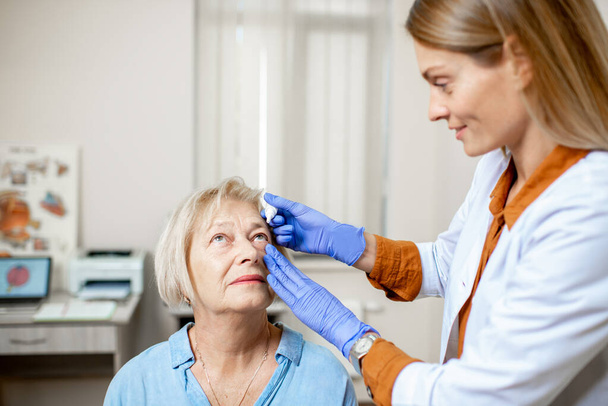 Médecin gouttes ophtalmiques gouttes sur les yeux d'un patient âgé
 - Photo, image