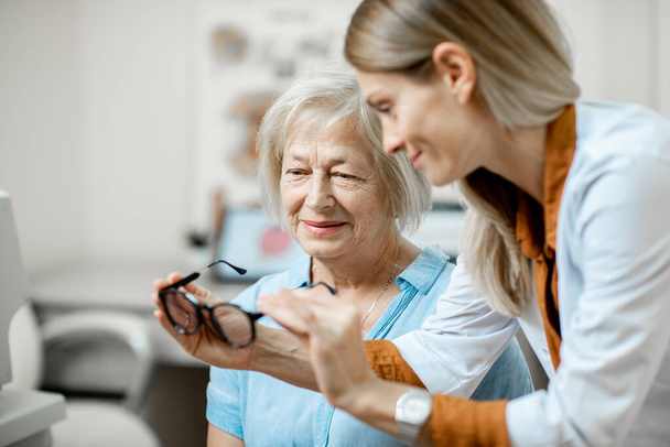 Ophtalmologiste avec patient âgé au bureau
 - Photo, image