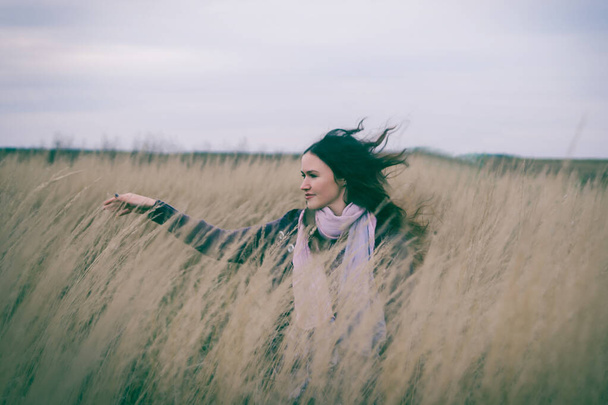 pretty young woman walking on a wheat field - Фото, зображення