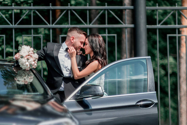 close up. bride and groom standing near the car - Foto, Imagen