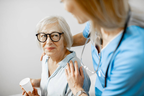 Enfermera cuidando de la mujer mayor
 - Foto, Imagen