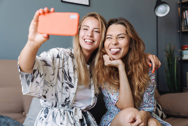 Optimistic women at home using mobile phone take a selfie. - Foto, Imagem