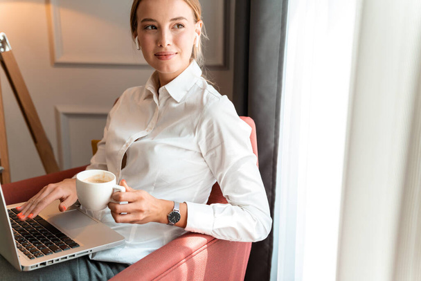 Business woman sit indoors in cafe drinking coffee. - Фото, изображение