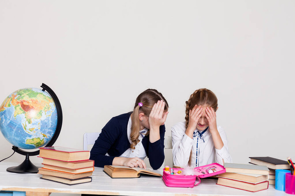twee schoolmeisjes aan het bureau in een aardrijkskunde klas - Foto, afbeelding