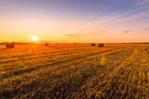 Сцена заката на поле с стогами сена осенним солнечным вечером
. - Фото, изображение