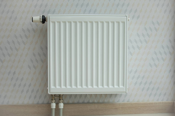 Witte radiator in een appartement. huisverwarming - Foto, afbeelding