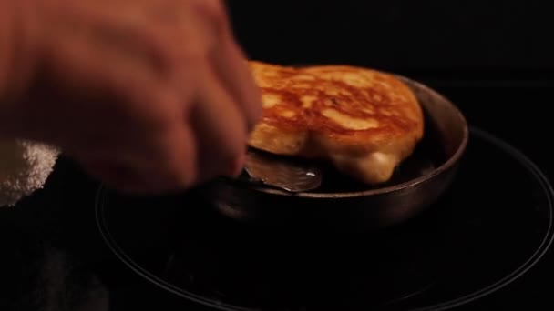 Woman hand is turning small pancake in little pan tasty - Filmati, video