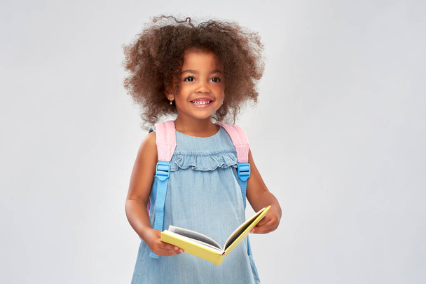 happy little african girl with book and backpack - Photo, Image