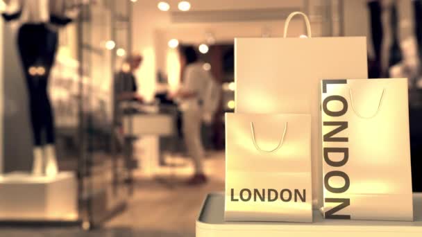 Kauppakassit LONDON tekstiä vastaan hämärtynyt myymälä. Brittiläinen ostokset liittyvät clip
 - Materiaali, video