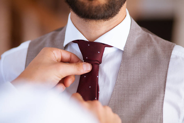Detailní záběr obou rukou pomáhá s kravatou na ženicha na jeho svatbě - Fotografie, Obrázek