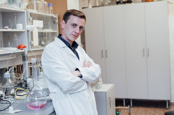 mężczyzna chemik prowadzi eksperymenty z płynami w laboratorium chemicznym - Zdjęcie, obraz