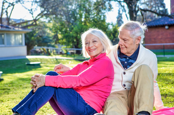 Ευτυχισμένο ηλικιωμένο ζευγάρι συνταξιούχων χαλαρωτικό υπαίθριο στον κήπο. Έννοια της συνταξιοδότησης. - Φωτογραφία, εικόνα