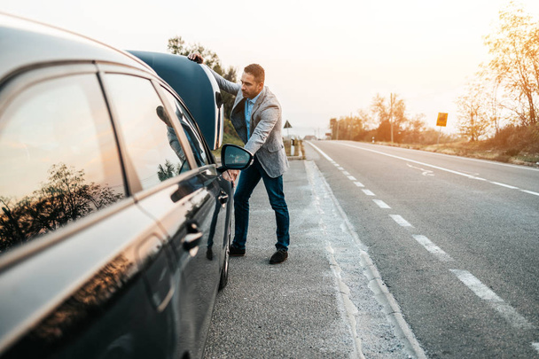 Car issue breakdown or engine failure. Elegant middle age man waiting for towing service for help car accident on the road. Roadside assistance concept. - Foto, Imagen