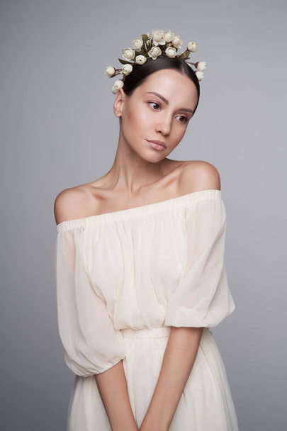 Woman in white greek dress with flowers on her head - Fotó, kép